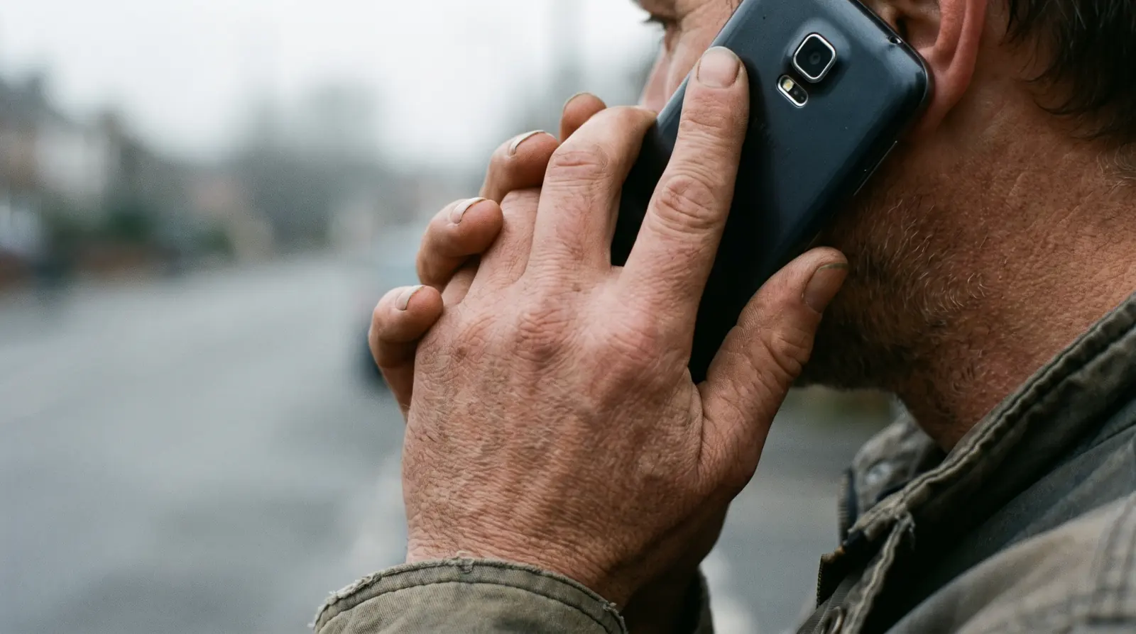 Hands holding a phone to an ear, the face out of frame